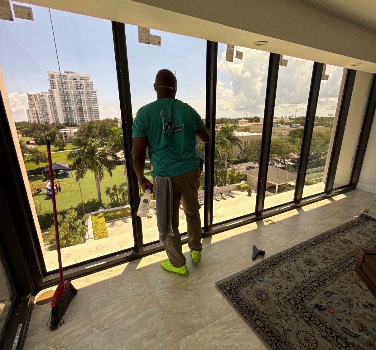 WindowLady installer inspecting newly installed impact sliding glass doors in a high-rise residence